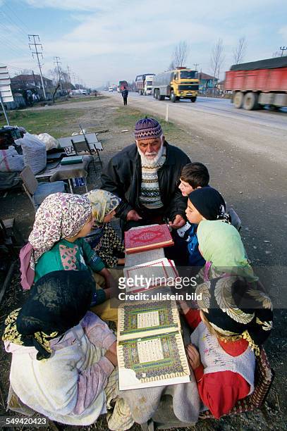 Turkey, Mittelmeer, Duezce: After the earthquake.- A hoca teaching little children how to read the Koran at the roadside in Kaynasil near Dueze.
