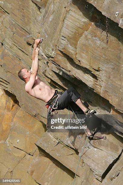 Germany, Hattingen: The climbing crag of the "Deutschen Alpenverein DAV Isenberg". A man climbs onto a rock