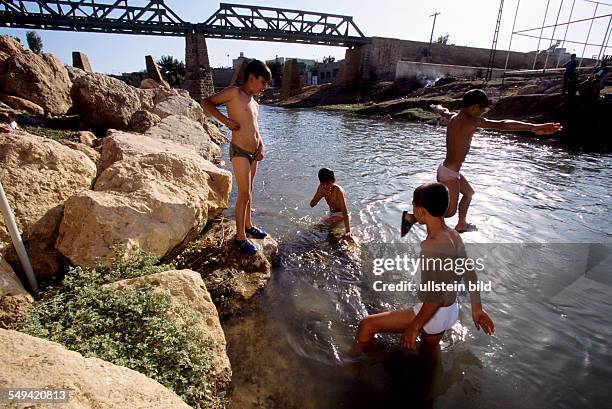 Turkey, Turkey on its way to Europe. Europe-Express, which drives from Nusaybin to Istanbul along the border to Syria. Children play under the rail...