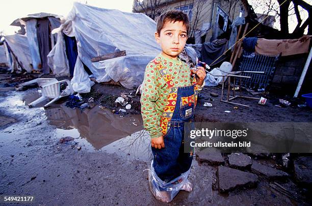 Turkey, Mittelmeer, Duezce: After the earthquake.- A child without shoes in front of the provisional accommodation/tent; plastic bags as an...