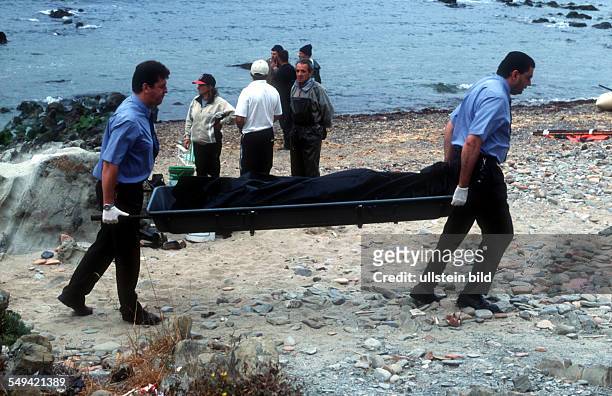 Spain, Africans try to immigrate over the straits of Gibraltar. Undertakers carry away the bodies.