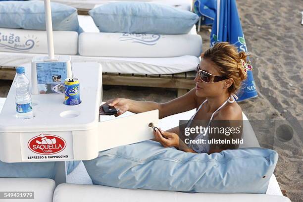 Turkey: Beach safe; portrait of a young woman sunbathing at the beach.