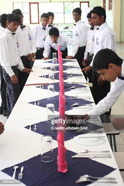 Sri Lanka, Kandy: Pupils of the Don Bosco center for vocational training for former street kids or children of poor families arrange the table...