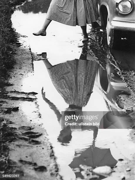 Woman, jumping over a puddle late fifties