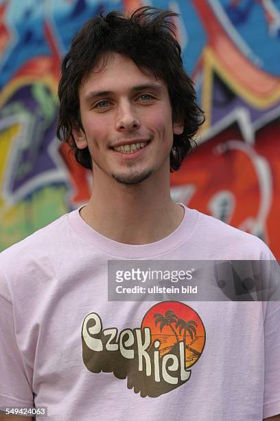 Germany: TITUS. - Portrait of a young man in front of a graffiti wall.
