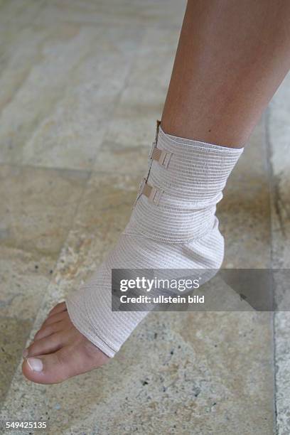 Germany, : The bandaged foot of a young woman; she has twisted her ankles while playing tennis.