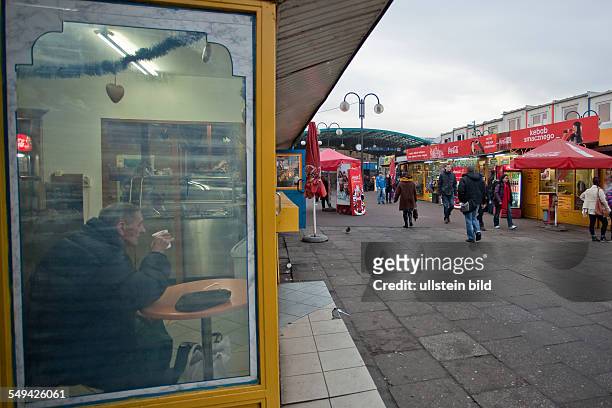 Poland, Krakow: man drinking coffee in a sidewalk cafe