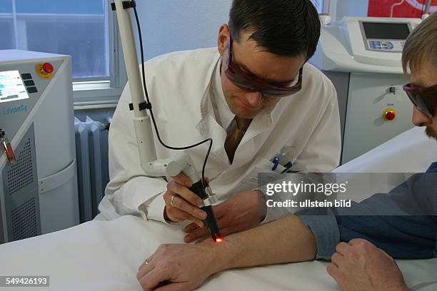 Germany, Essen, medicine physicist and non-medical practitioner Holger May, manager of the Laser Forum Essen. A patient during a laser treatment....