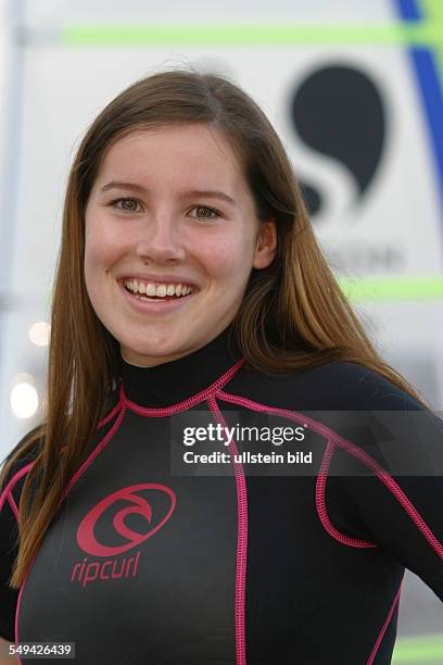 Germany, : Portrait of a young woman in surfing clothes.