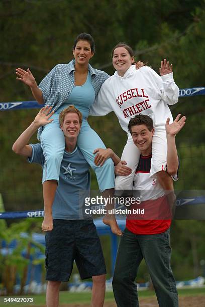 Germany, : Holidays.- Four youth on a beach volleyball field; the girls sitting on the boy s shoulders.