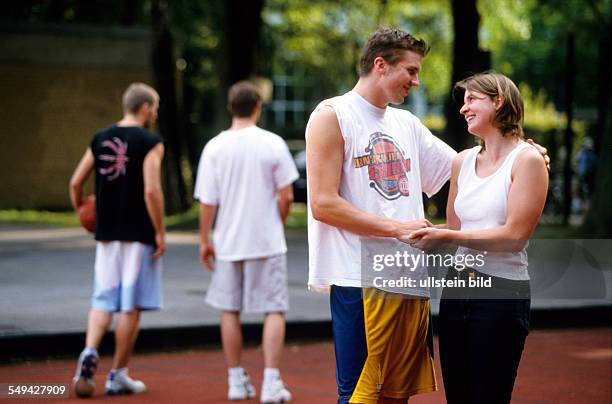 Germany: Free time.- Teenager; a couple on a baskatball field.