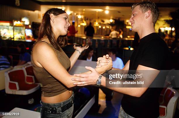 Germany: Free time.- Young persons bowling; at the bowling alley.