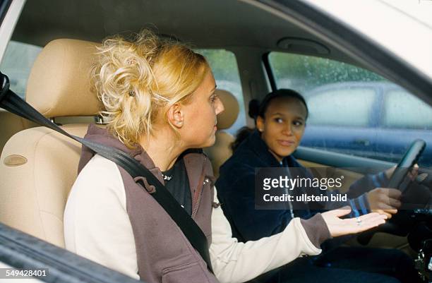 Germany: Free time.- Two young women driving a car.