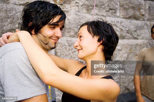 Germany: Free time.- Young persons after climbing; a woman and a man embracing.