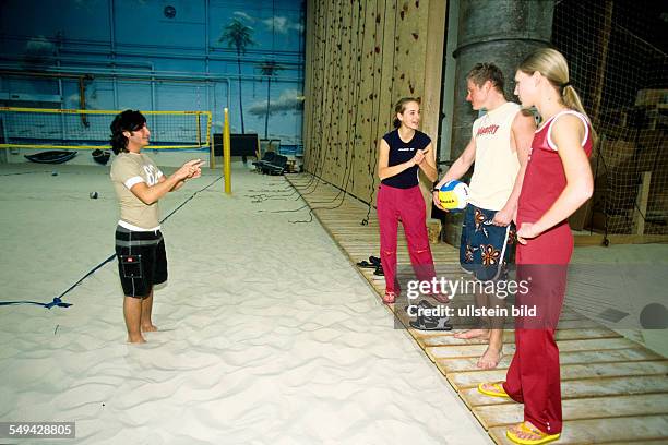 Germany: Free time.- Four youth doing sports; in a beachvolleyball hall.