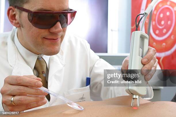 Germany, Essen, medicine physicist and non-medical practitioner Holger May, manager of the Laser Forum Essen. A patient during a laser treatment....