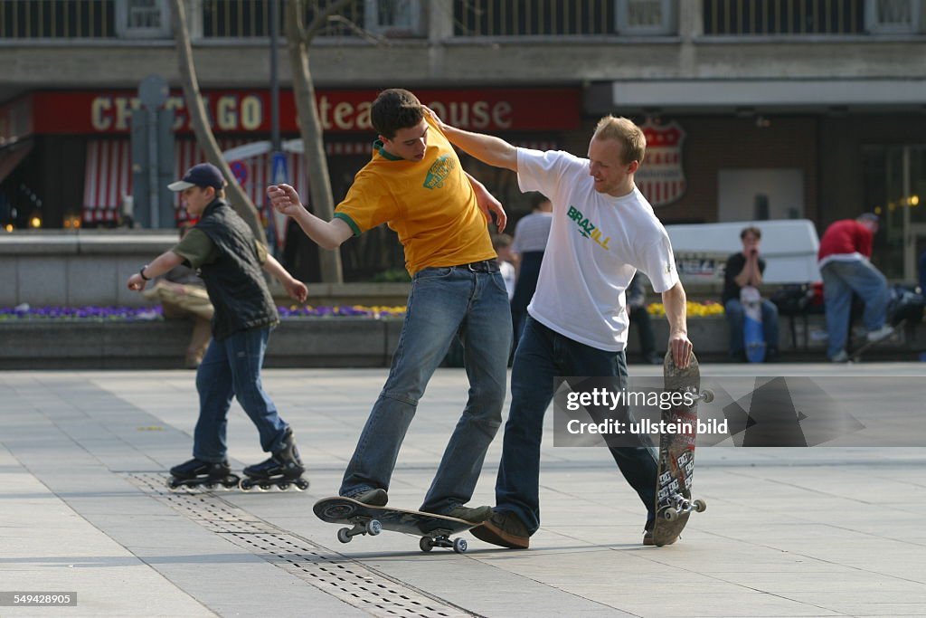 DEU, Germany, Cologne: Youth in their free time.- Young men skateboarding on the square in front of the cathedral.