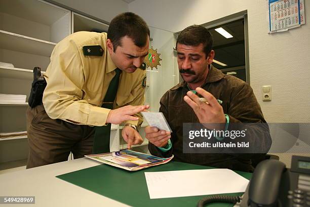 Germany: Yildiray Kara, 34 years old, police inspector with turkish origin . The inspector is checking the identity details of an Iraqi refugee.