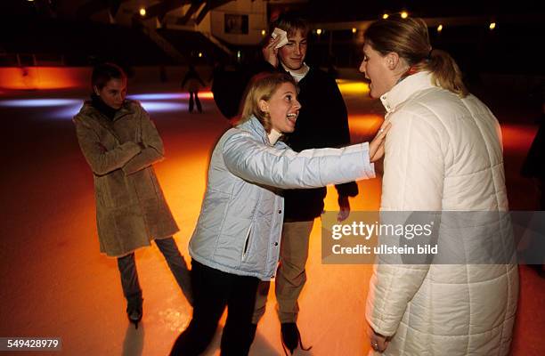 Germany: Free time.- While skating in an ice-skating rink; talk between youth.