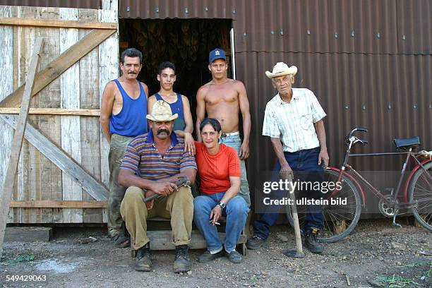 Cuba: Portrait of a group Cuban persons standing around the storeman, family business.