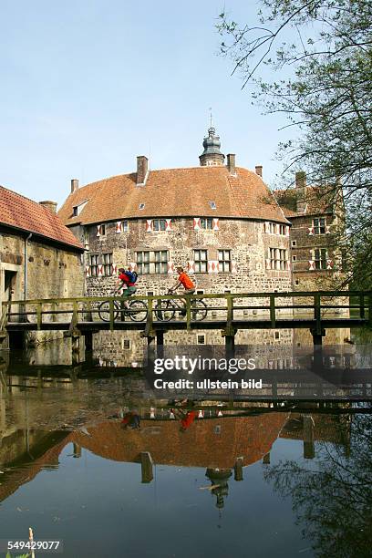 Germany: Bicycle tour through the Muensterland.- Over an old wooden bridge to Vischering Castle in Luedinghausen.