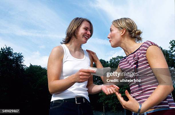 Germany: Free time.- Two women are happy, one of them has a piece of paper in her hand.