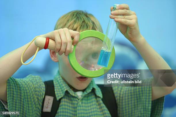 Germany: Research. - Portrait of a boy while he is experimenting.