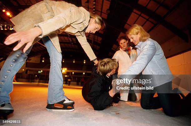 Germany: Free time.- While skating in an ice-skating rink; a boy falled and is lieing on the ice being injured.