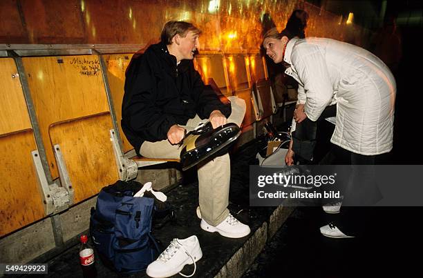 Germany: Free time.- Two youth in an ice-skating rink; they are putting on their skates.