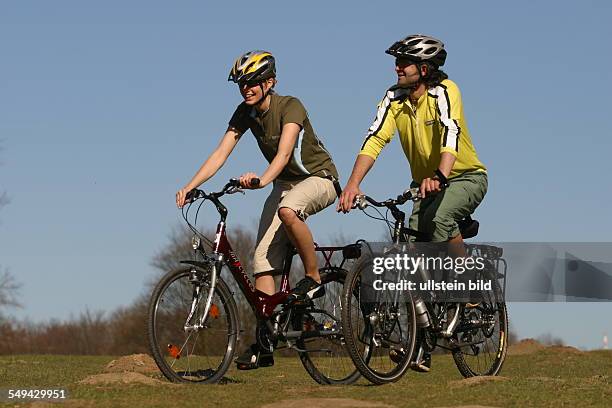 Germany, Cologne: Free time.- Young couple on their mountainbike tour through the green.