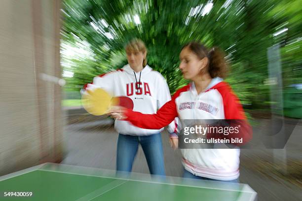 Germany, : Young persons playing table tennis.