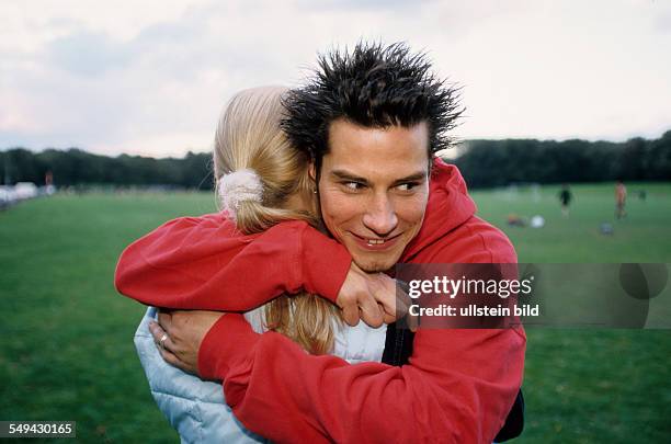 Germany: Free time.- Two youth on a meadow; they are embracing each other.