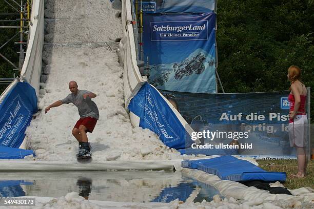 Germany, Neuss: Young persons in their free time.- A young man on a snowboard ramp.