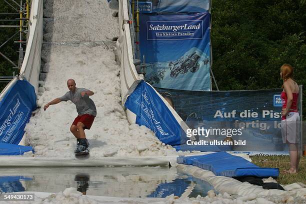 Germany, Neuss: Young persons in their free time.- A young man on a snowboard ramp.