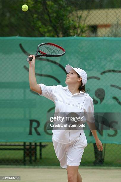 Germany, : A young woman playing tennis.