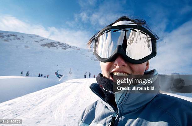 Germany: Free time.- Portrait of a young woman in the snow in the mountains.