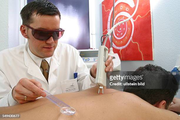 Germany, Essen, medicine physicist and non-medical practitioner Holger May, manager of the Laser Forum Essen. A patient during a laser treatment....