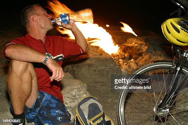 Turkey: A man next to a camp fire at the beach.