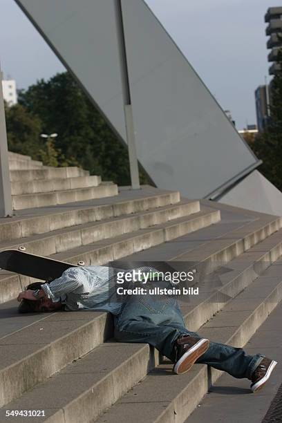 Germany: Young persons in their free time.- Skateboarding; a young man being injured after falling on the stairs.