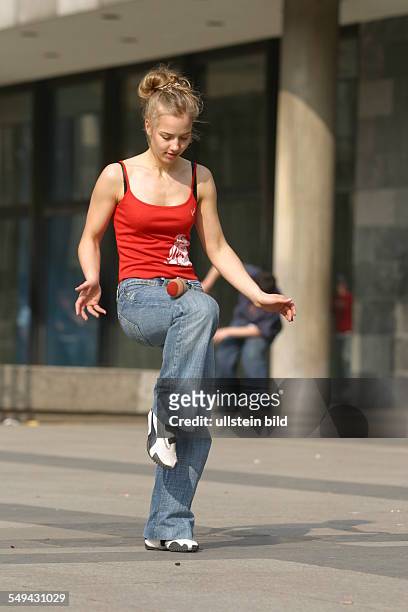 Germany, Cologne: Youth in their free time.- A young woman playing with a ball.