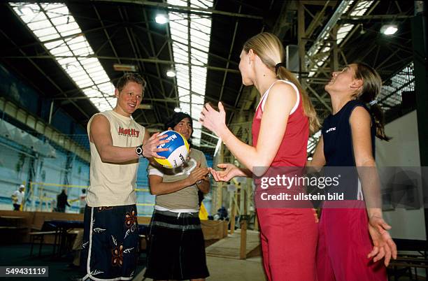 Germany: Free time.- Four youth doing sports; in a beachvolleyball hall.