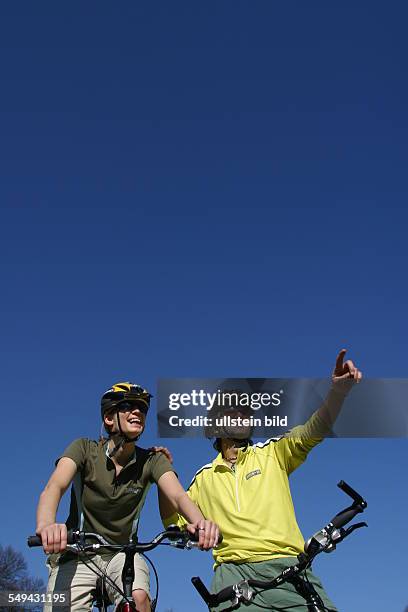 Germany, Cologne: Free time.- Young couple on their mountainbike tour through the green.