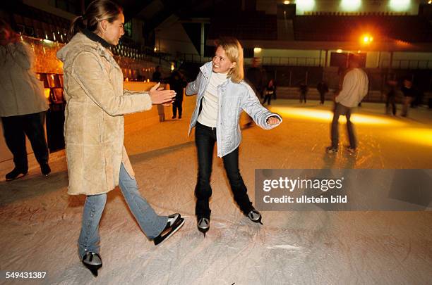 Germany: Free time.- Two young girls in an ice-skating rink; skating.