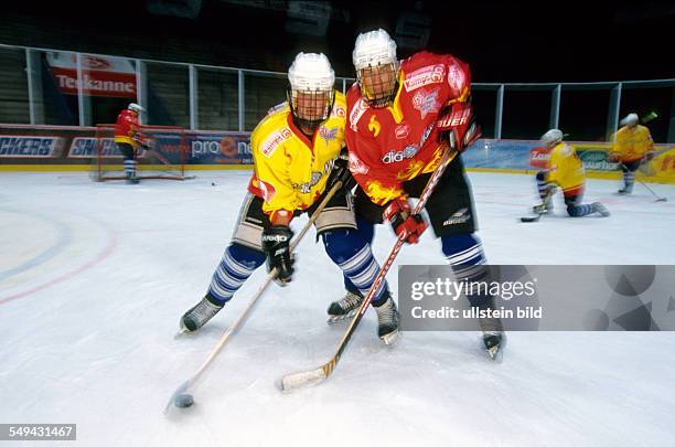 Germany: Free time.- Young persons playing ice hockey.