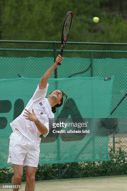 Germany, : A young man playing tennis.