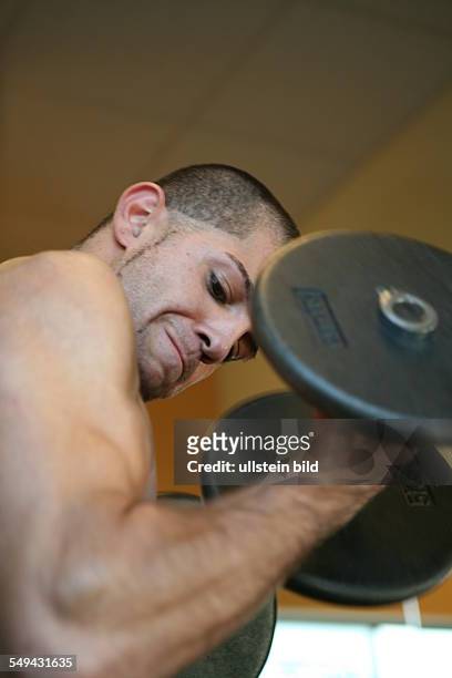 Germany, Wesseling: A young turkish man during his practise in a fitness studio. Joerg Boerjesson advices and informs him about anabolic steroids and...