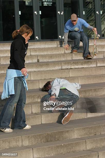 Germany: Young persons in their free time.- Friends are skateboarding; a young man being injured after falling on the stairs.