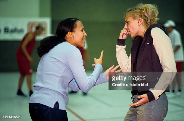 Germany: Free time.- Two young women in a gymnasium; discussion.