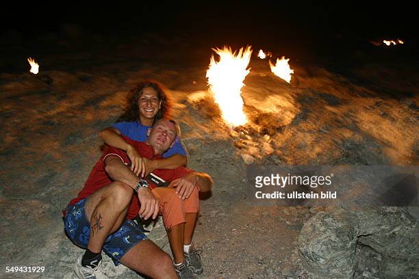 Turkey: A couple having a camp fire at the beach.