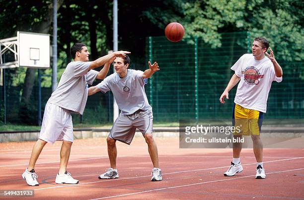 Germany: Free time.- Young persons playing basketball.